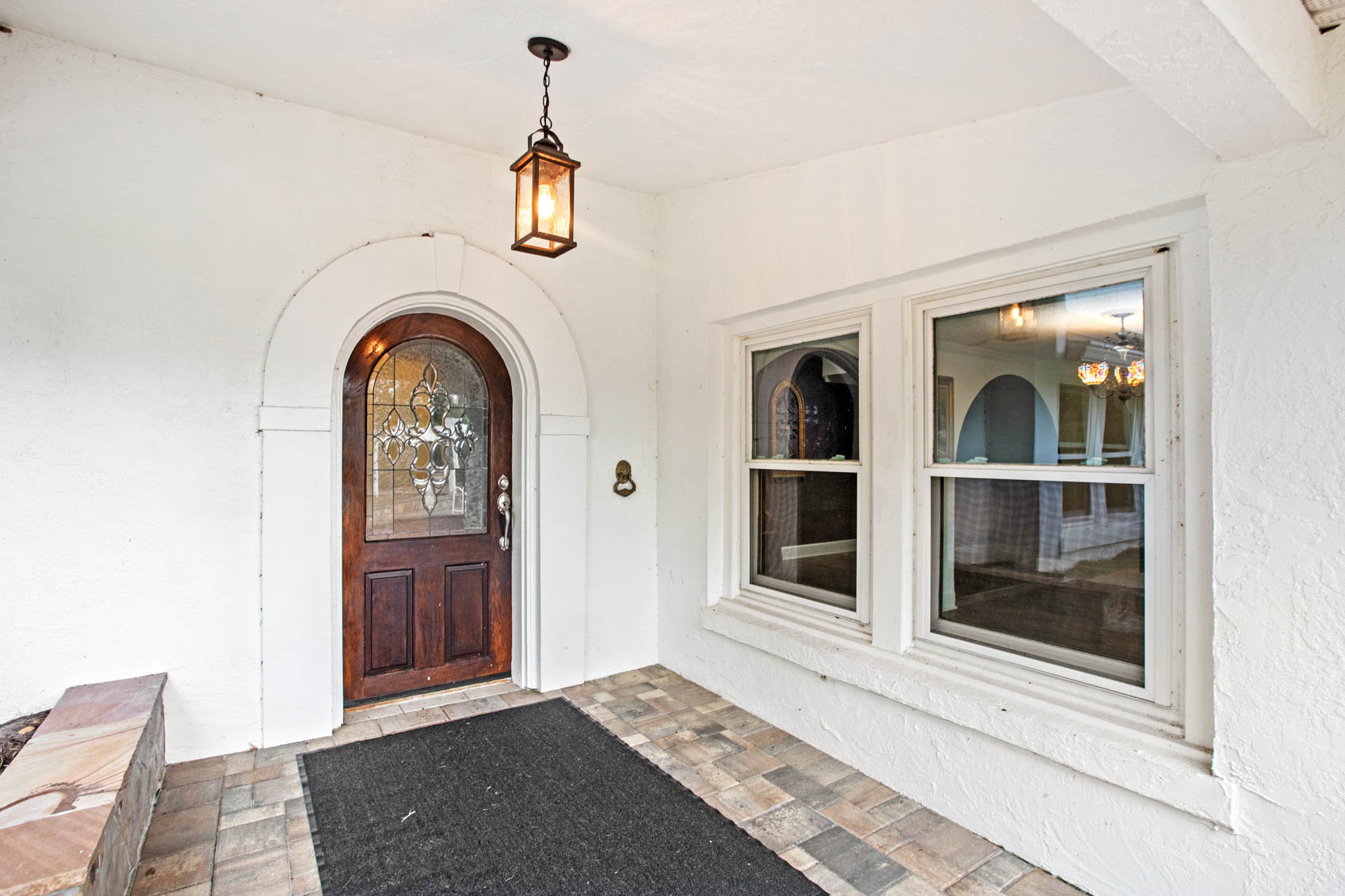outside front door with wood door and white paint